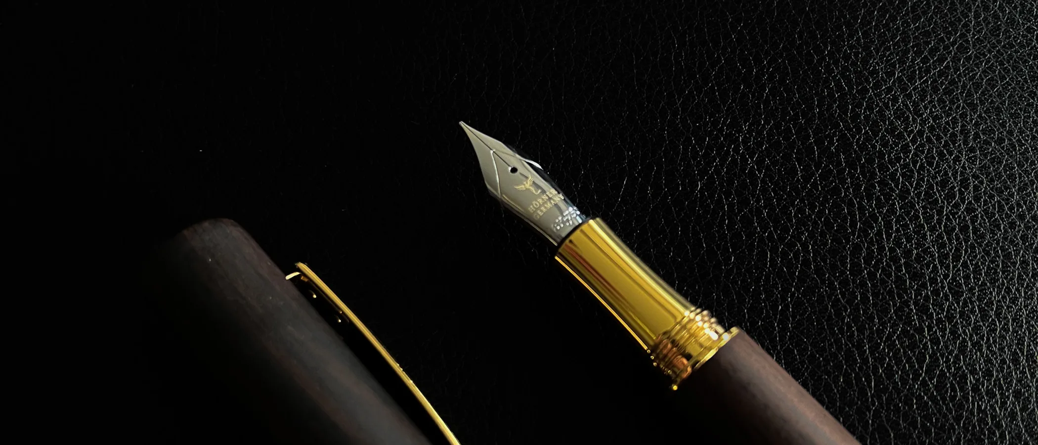 A Hörner Scriptum ebony fountain pen with a gold nib on black leather