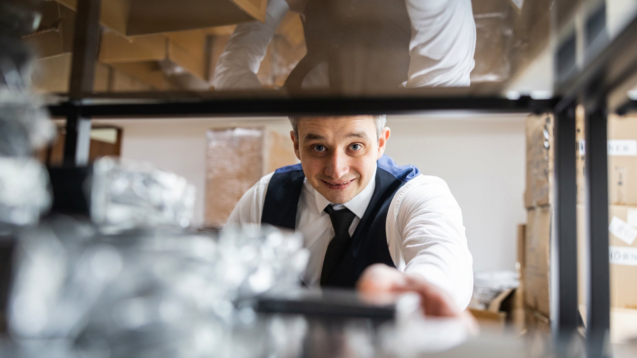 Andre Hörner, founder of Hörner, reaching into a stock shelf in the Dresden warehouse