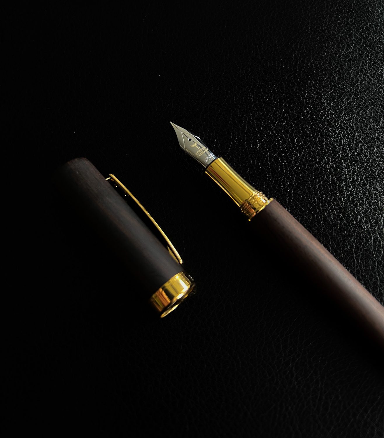 Hörner Scriptum ebony fountain pen with its gold nib on dark leather